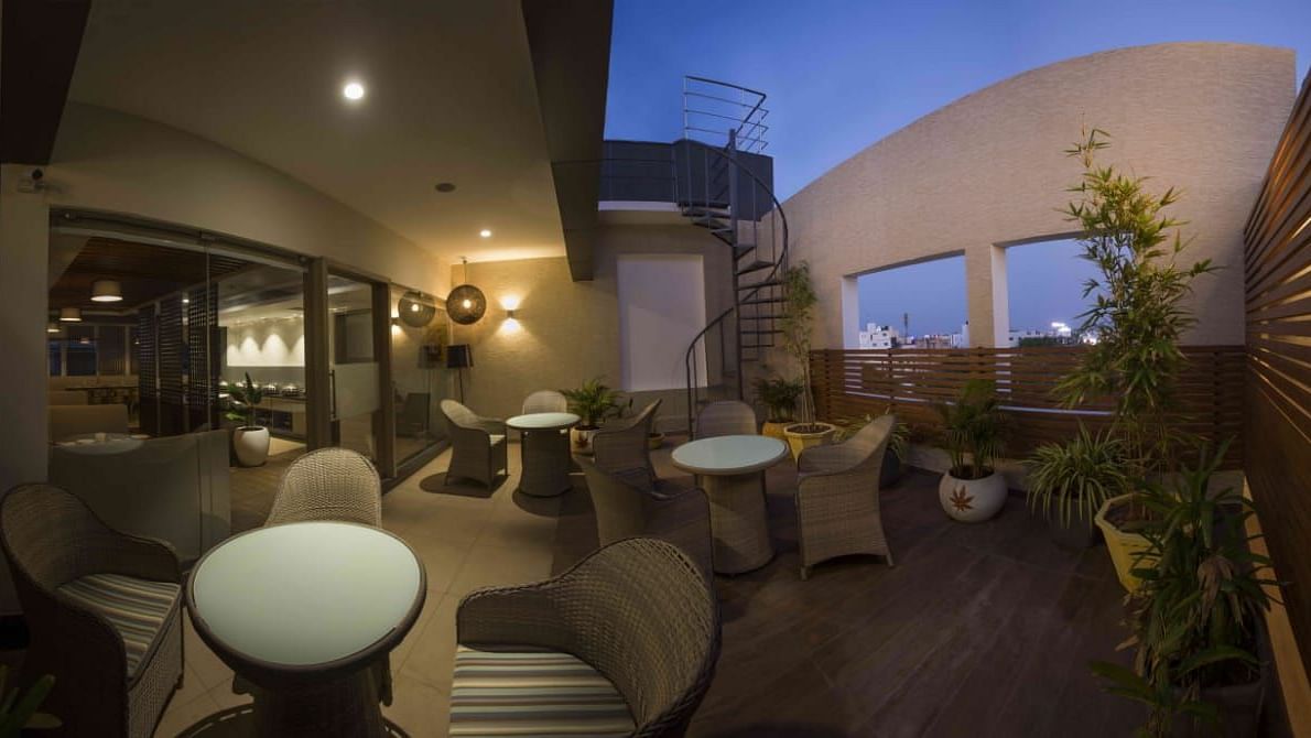 Mint N Mustard Rooftop Restaurant at Mayberry Tiruppur with an open roof with plants and a relaxed dining atmosphere